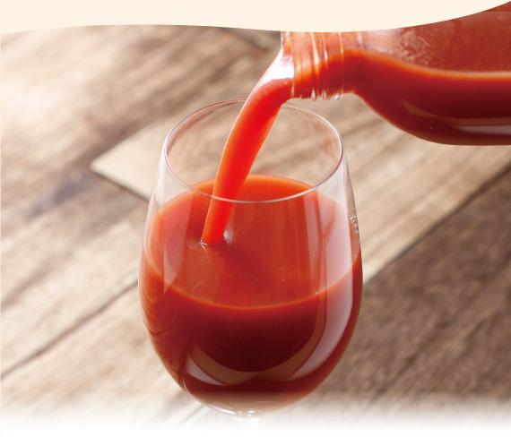 トマトジュースをグラスに注ぐ様子