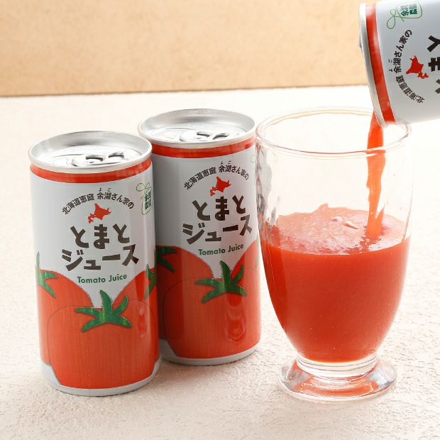トマトジュースをコップに注いでる様子と並べた缶