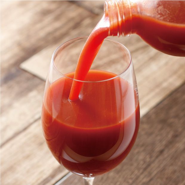 トマトジュースをグラスに注ぐ様子